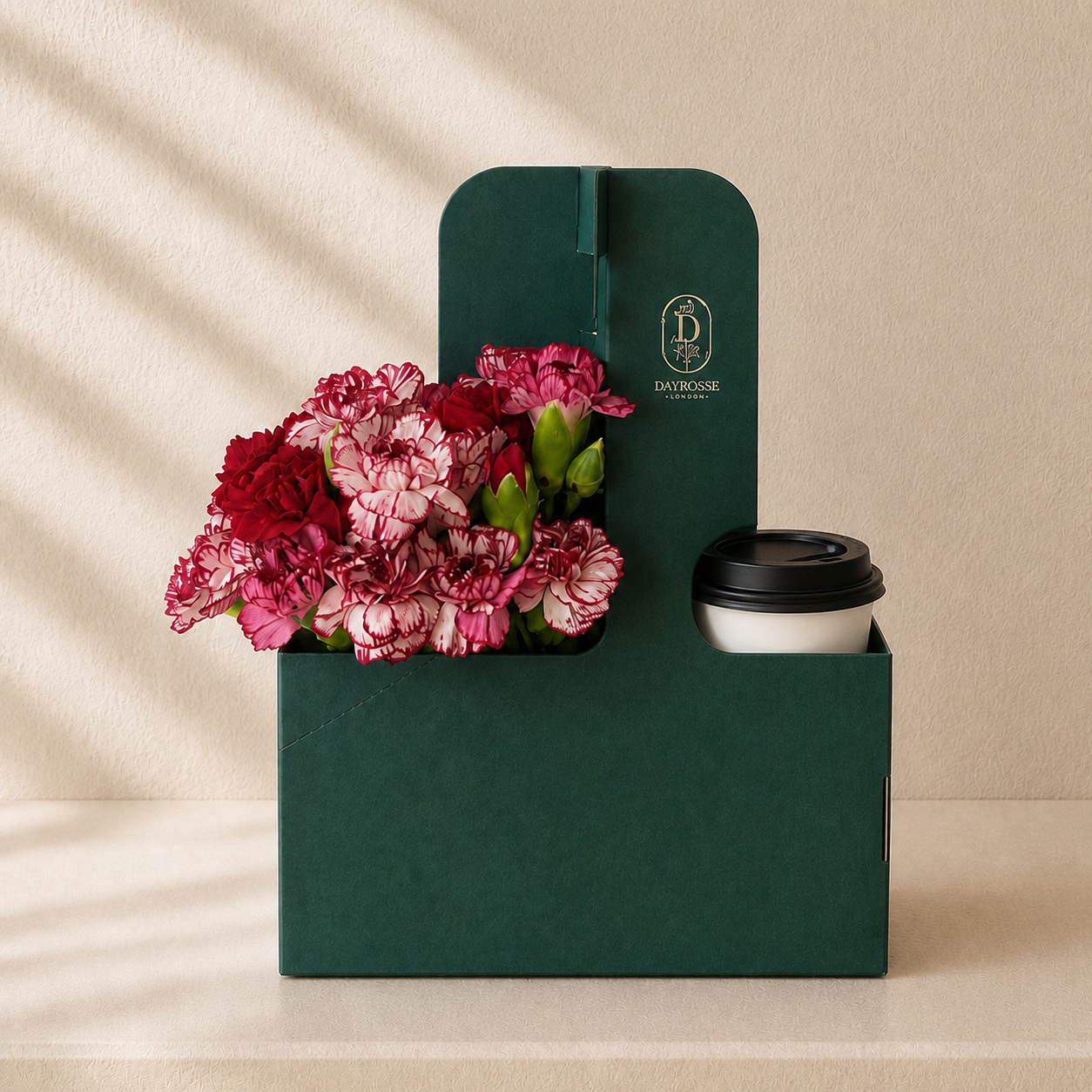 Caja verde DAYROSSE con flores de temporada y bebida con tapa negra