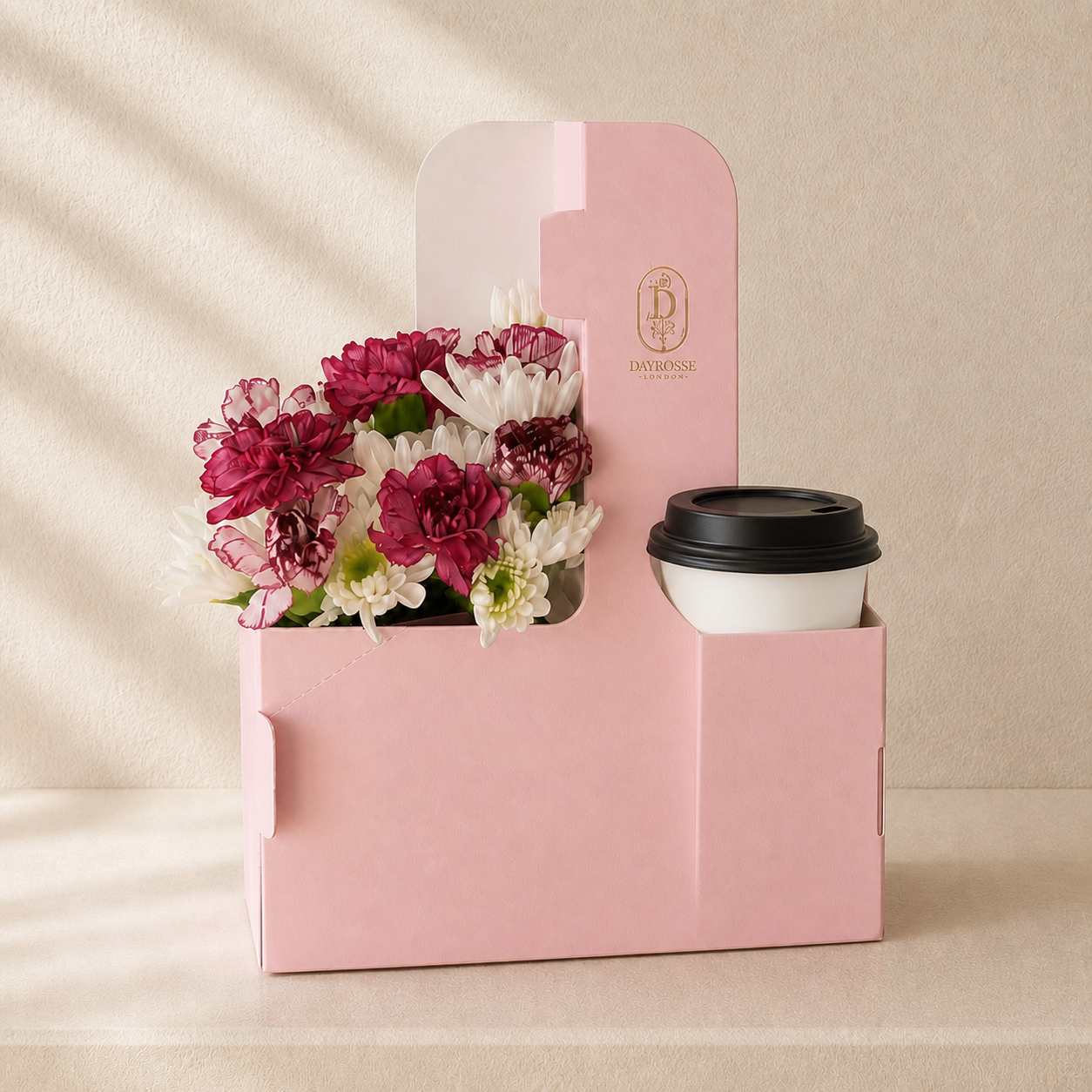 Caja rosa DAYROSSE con flores de temporada y bebida con tapa negra